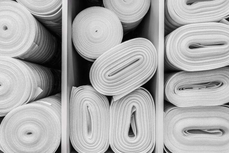 Industrial white foam rolls or thermal insulation materials in a hardware store. Laminate and parquet flooring in rolls close-up. Corrosion-resistant, environmentally friendly and safe material.